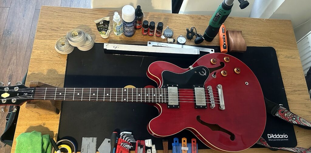 Red Epiphone Dot on the RG Guitar Tech workbench after a full fret level, crowning, setup and electrical repair