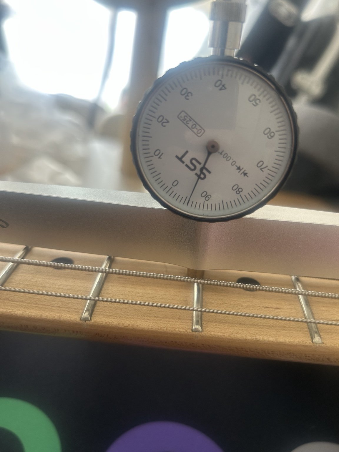 Bass guitar neck relief being measured with a dedicated gauge during a Nottingham setup