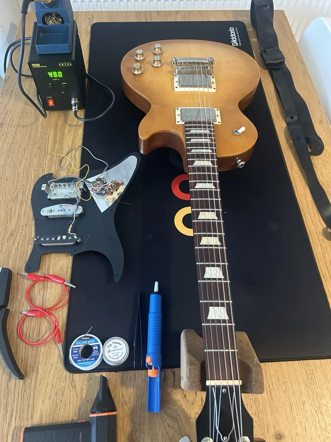 Les Paul-style guitar with electronics components during a professional repair
