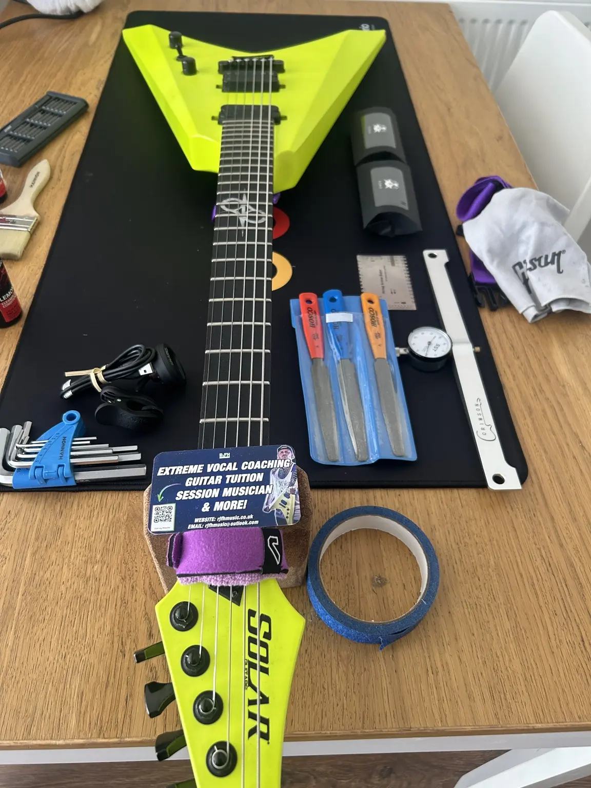 Neon yellow V-shaped electric guitar undergoing a professional setup in Nottingham