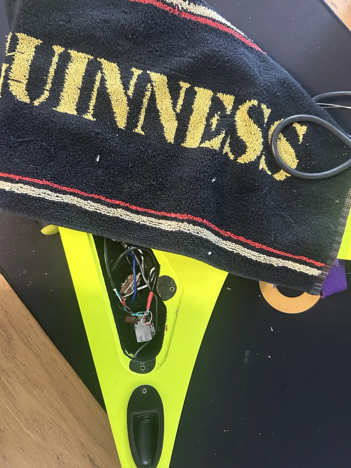 Neon yellow V-shaped electric guitar during an electronics repair in Nottingham