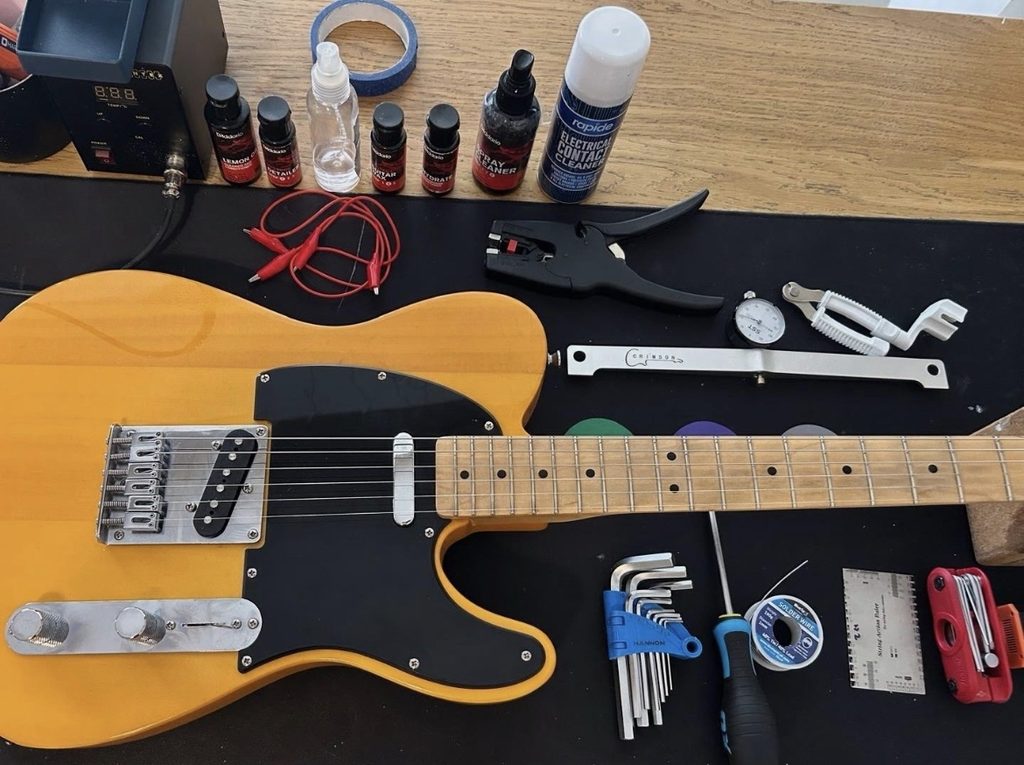 Telecaster-style electric guitar with professional setup tools on an RG Guitar Tech workbench in Nottingham