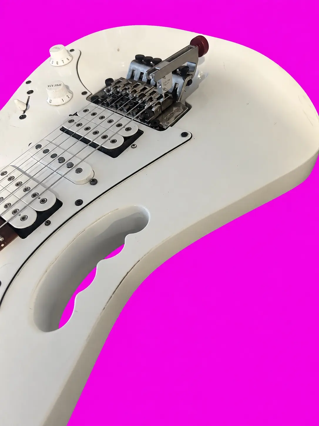 White electric guitar with Floyd Rose bridge during a professional setup